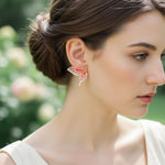 Woman wearing butterfly earrings with a blurred natural background