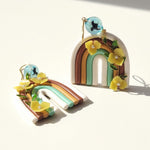Rainbow polymer clay earrings with yellow hydrangea flowers and gold-plated hooks on a white background
