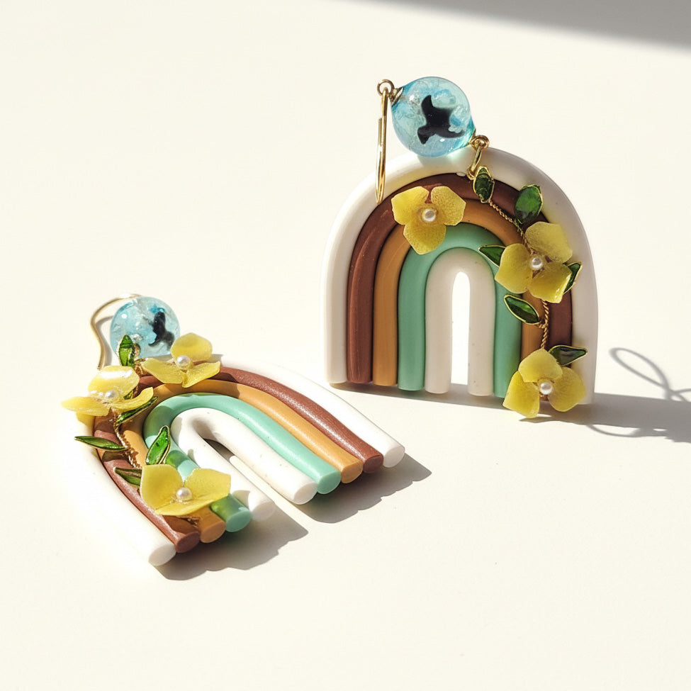 Rainbow polymer clay earrings with yellow hydrangea flowers and gold-plated hooks on a white background