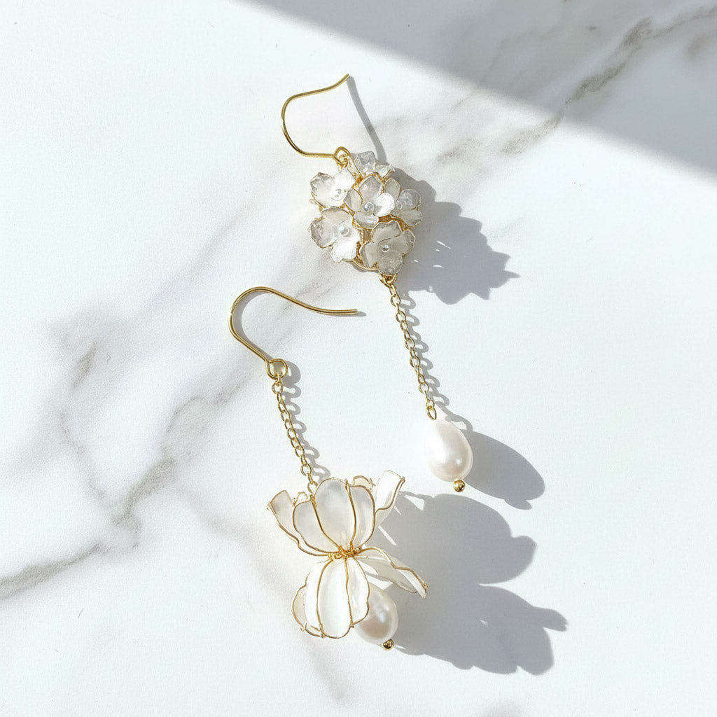 Pair of floral earrings with gold accents on a marble surface