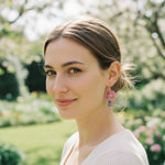 Woman wearing pink floral earrings in a garden setting