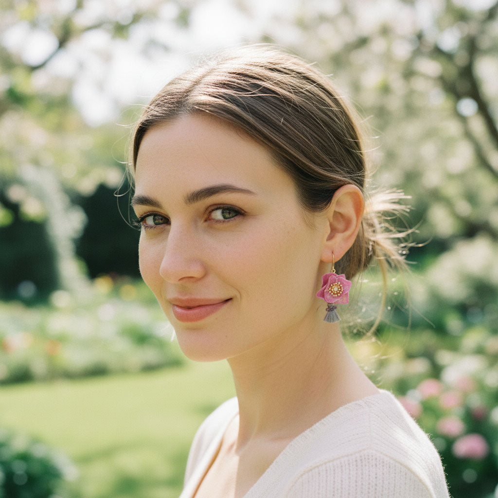 Woman wearing pink floral earrings in a garden setting