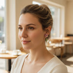Woman wearing earrings in a blurred indoor setting