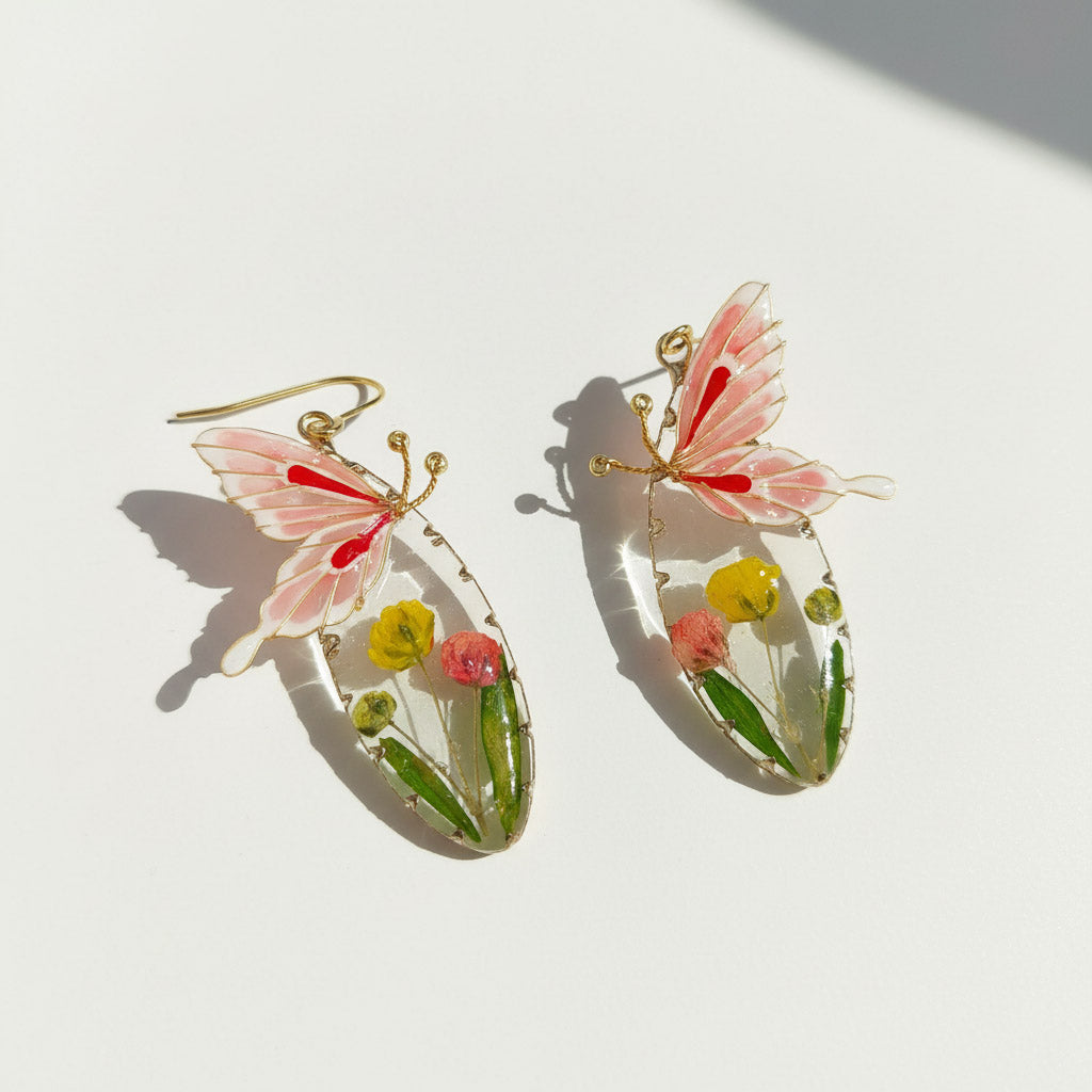 Butterfly-shaped earrings with floral details on a white background