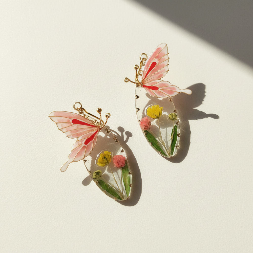Butterfly-shaped earrings with floral details on a light background