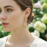 Woman wearing butterfly earrings with a blurred floral background