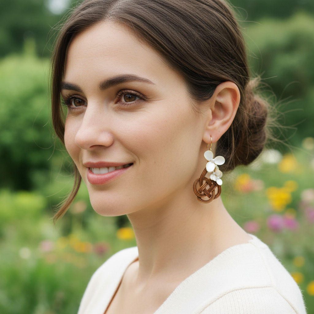 Woman wearing floral earrings with a blurred natural background
