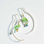 Pair of gold earrings with green bird-shaped charms on a light gray background