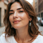 Woman with styled hair and earrings in an urban setting