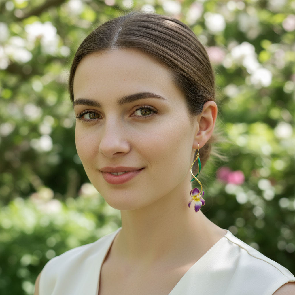 Model wearing A2K London hand-painted iris drop earrings in garden sunlight, elegant floral statement style.