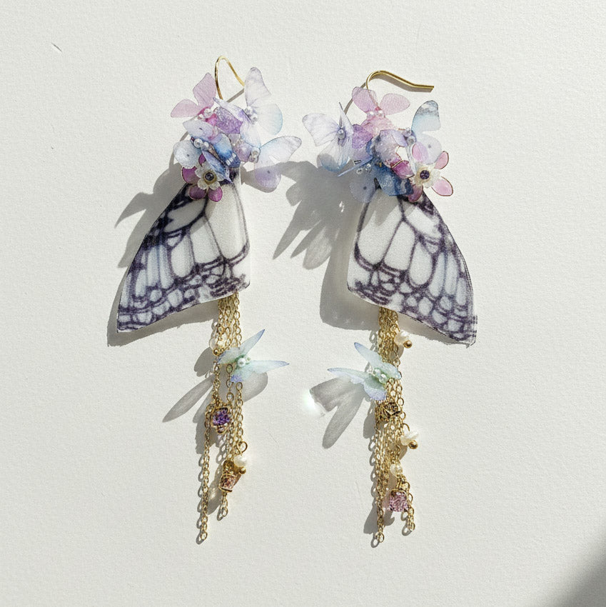 Pastel butterfly wing earrings with gold-plated chains and resin flowers.