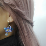 Model wearing short hydrangea hoop earring with real preserved flowers, hand-painted resin petals, and gold-plated hardware.