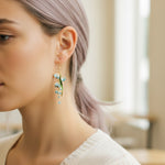Close-up of a woman wearing a delicate earring with a blurred background