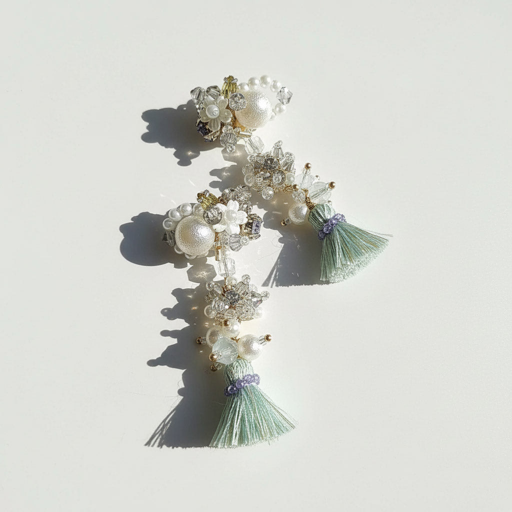 Decorative earrings with pearls and tassels on a light background