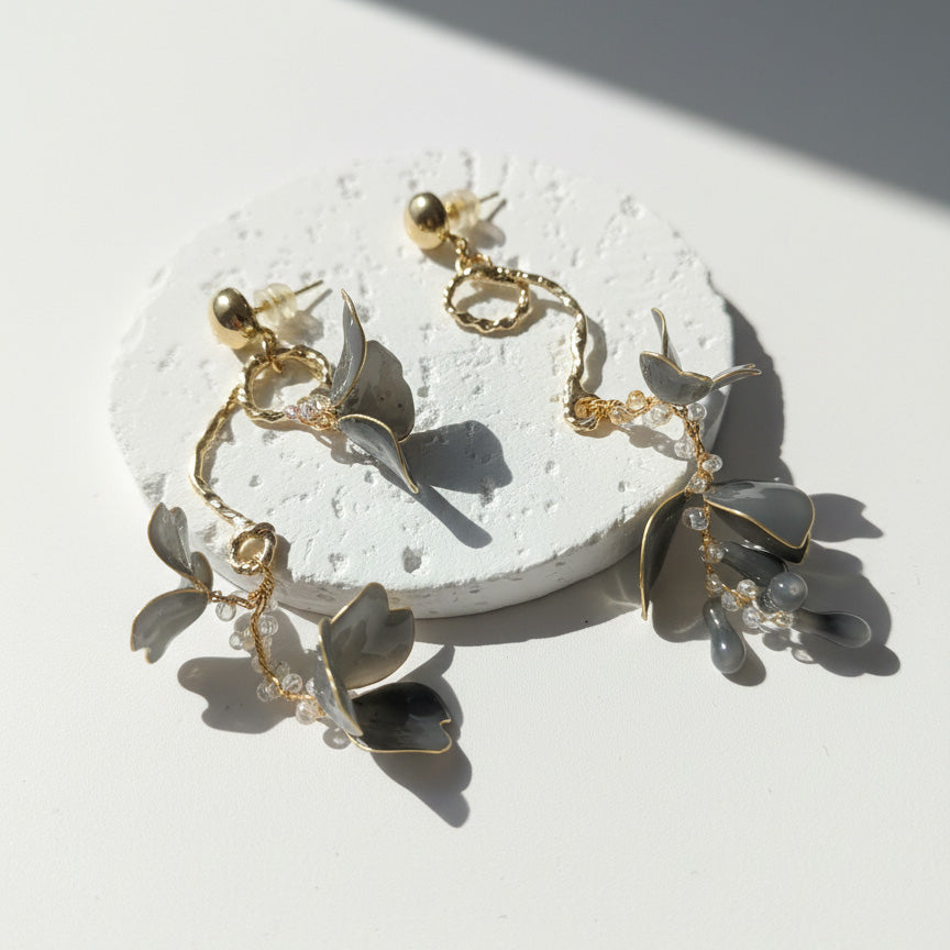 Gold bracelet with leaf-like charms on a white surface