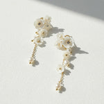 Floral pearl drop earrings with resin flowers and gold-plated accents.