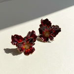 Pair of red floral earrings on a light background