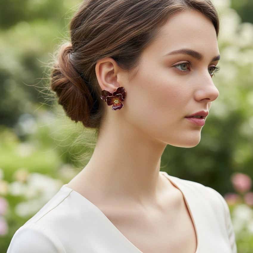 Woman wearing floral earrings with a blurred natural background