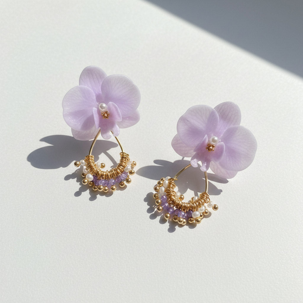 Pair of earrings with purple floral elements on a light background