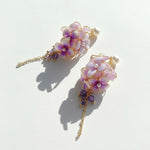 Floral hairpins with purple and white flowers on a light background