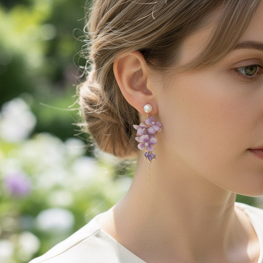 Close-up of a woman wearing floral earrings with a blurred natural background