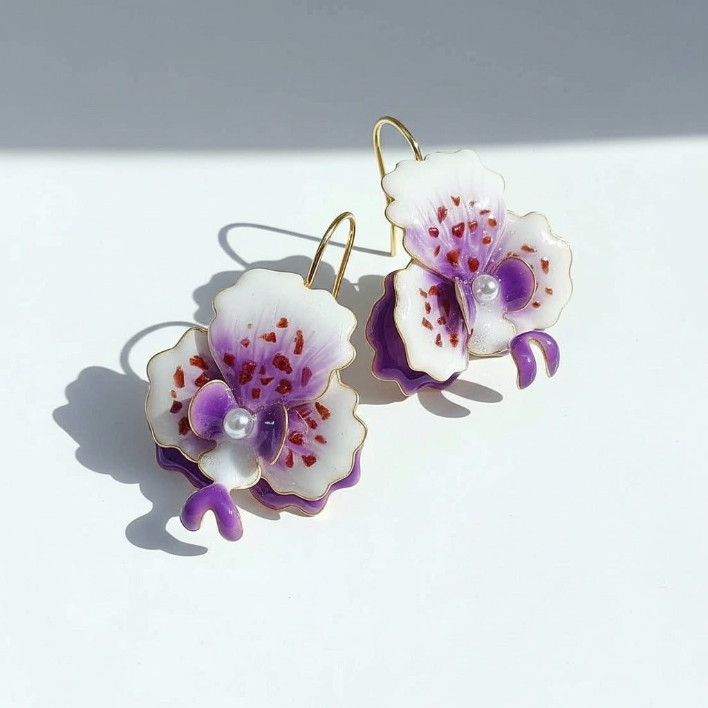 Pair of floral earrings with purple and white flowers on a light gray background