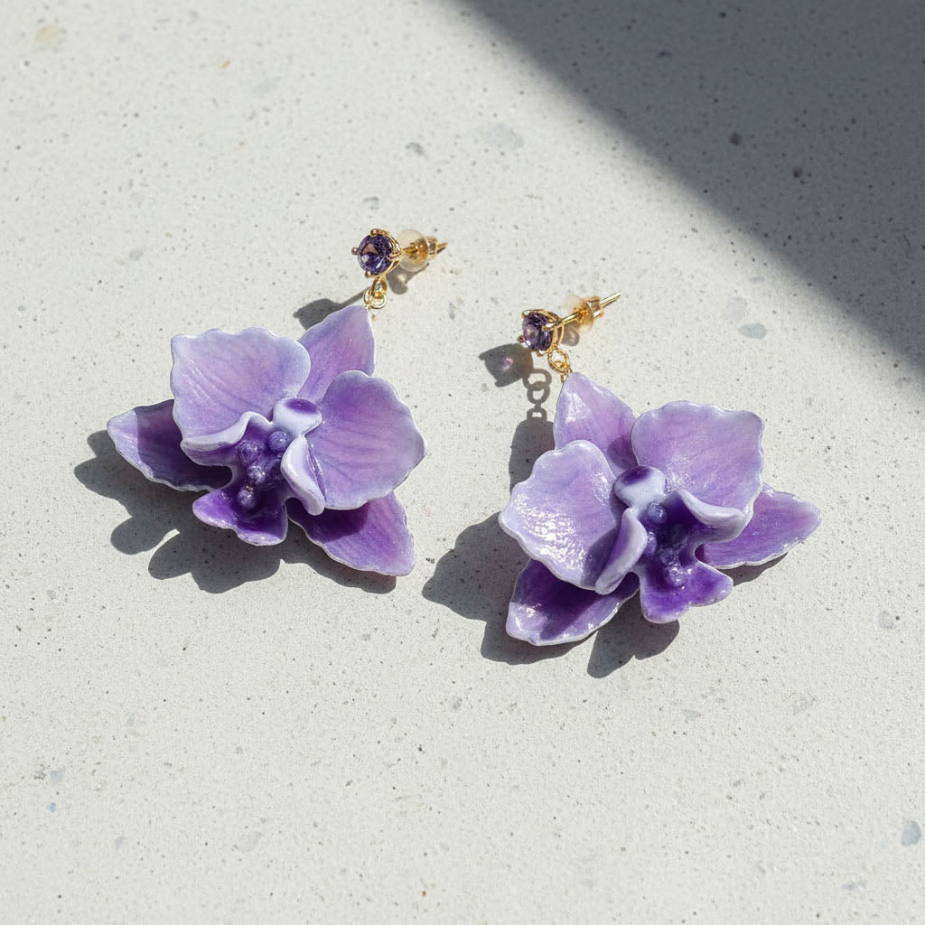 Purple flower-shaped earrings on a light gray surface