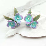 Pair of floral earrings with pastel colors on a white surface
