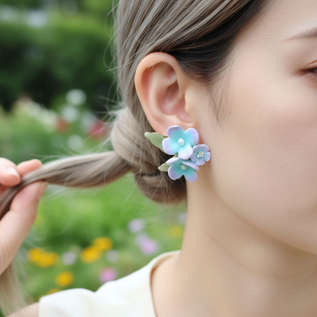 Woman wearing a floral earring with a blurred garden background