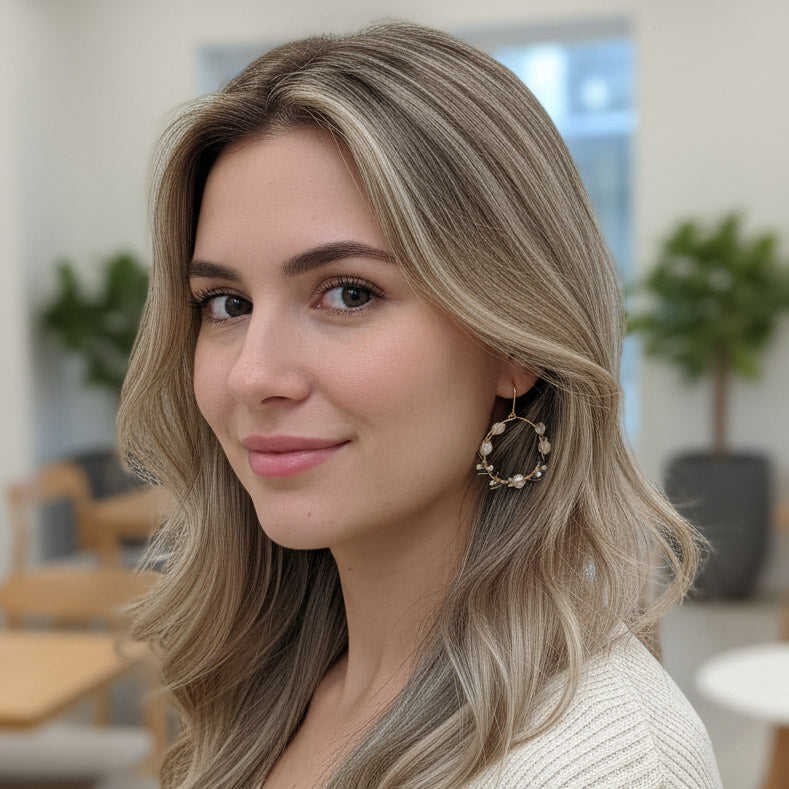 Woman with styled hair and earrings in an indoor setting