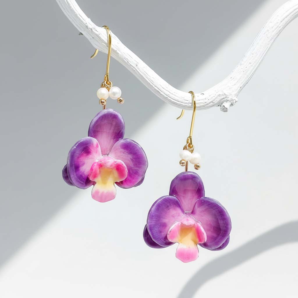 Purple orchid flower earrings with gold hooks on a white background
