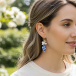 Woman wearing floral earrings with a blurred natural background