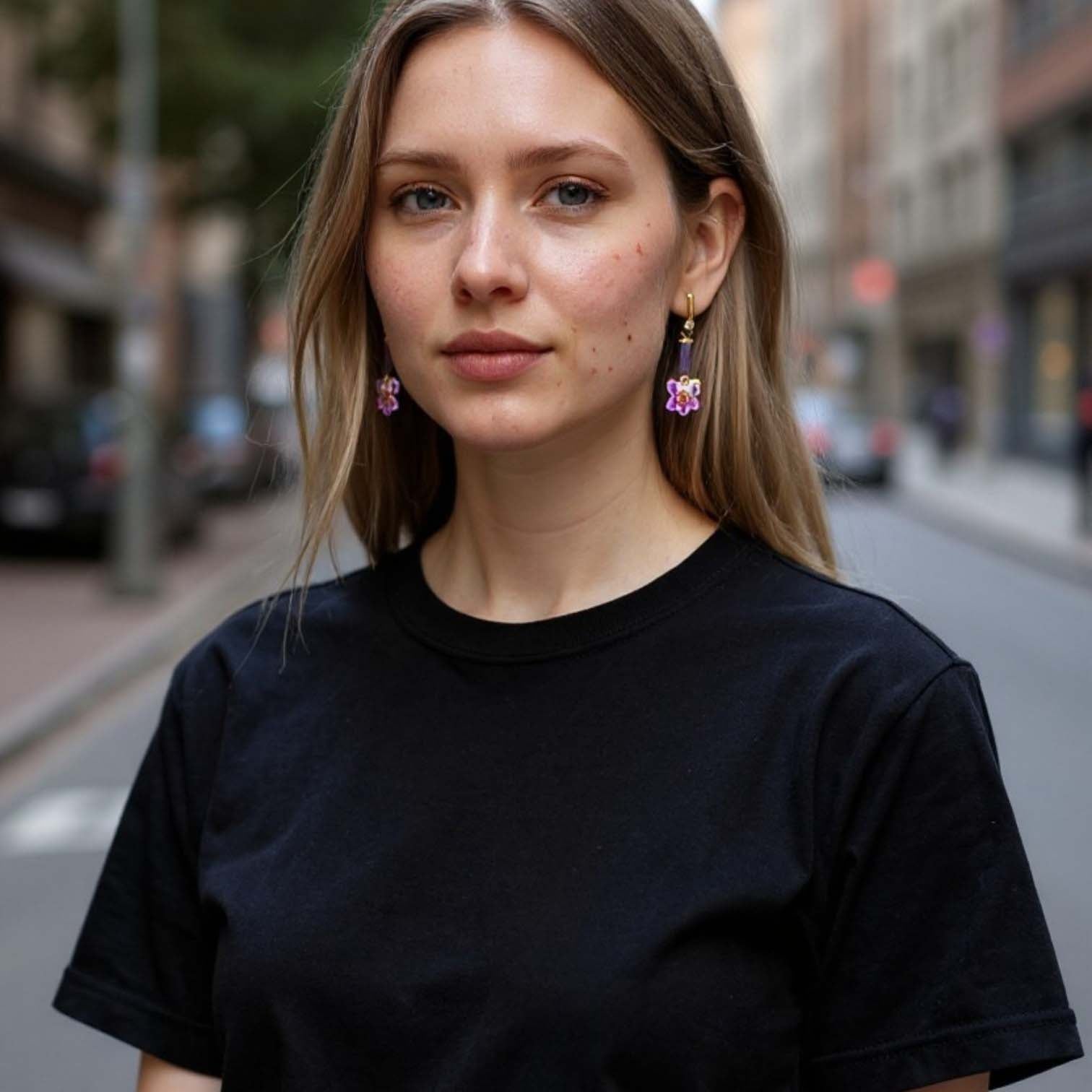 Woman wearing a black t-shirt with a blurred city street background