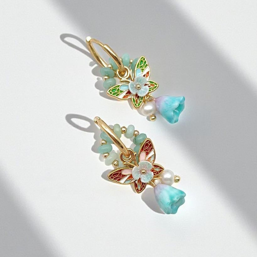 Butterfly-shaped hair clips with floral details and beads on a light background