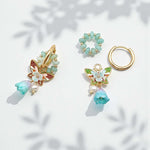 Set of earrings with gold and green accents on a light background