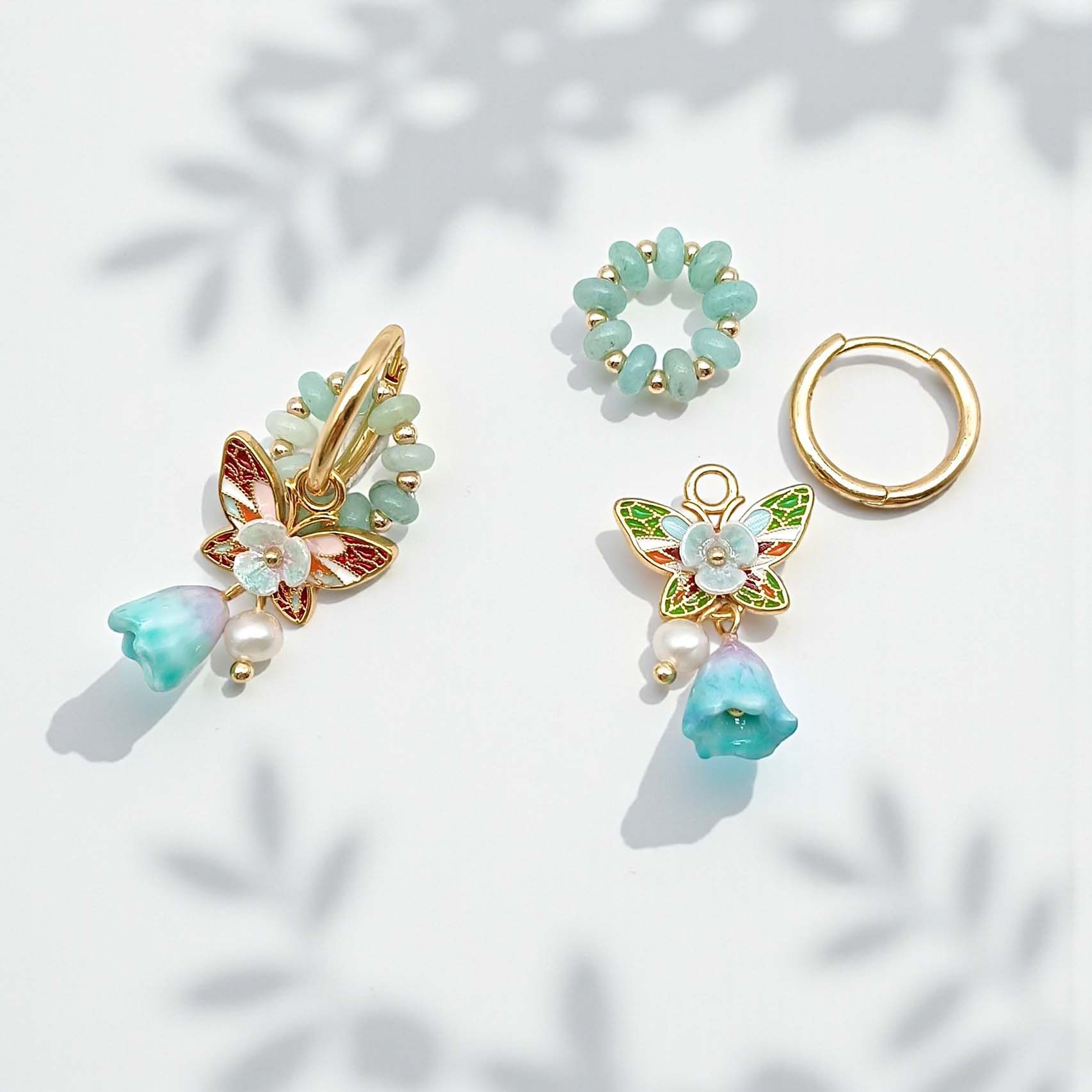 Set of earrings with gold and green accents on a light background