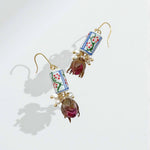 Decorative earrings with floral designs on a light background
