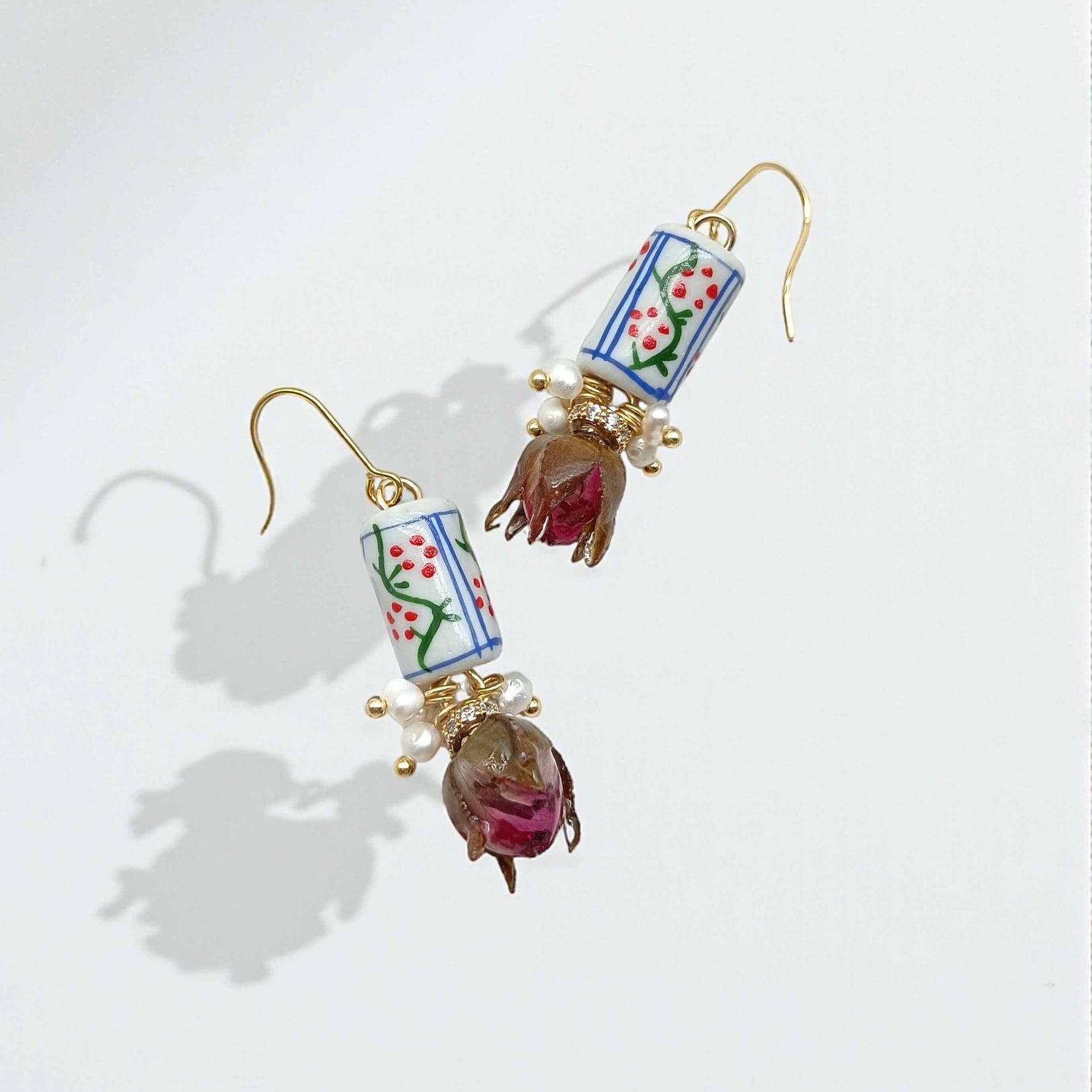 Decorative earrings with floral designs on a light background