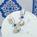 Decorative earrings with floral patterns on a white surface