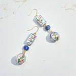 Pair of earrings with floral design beads on a light background