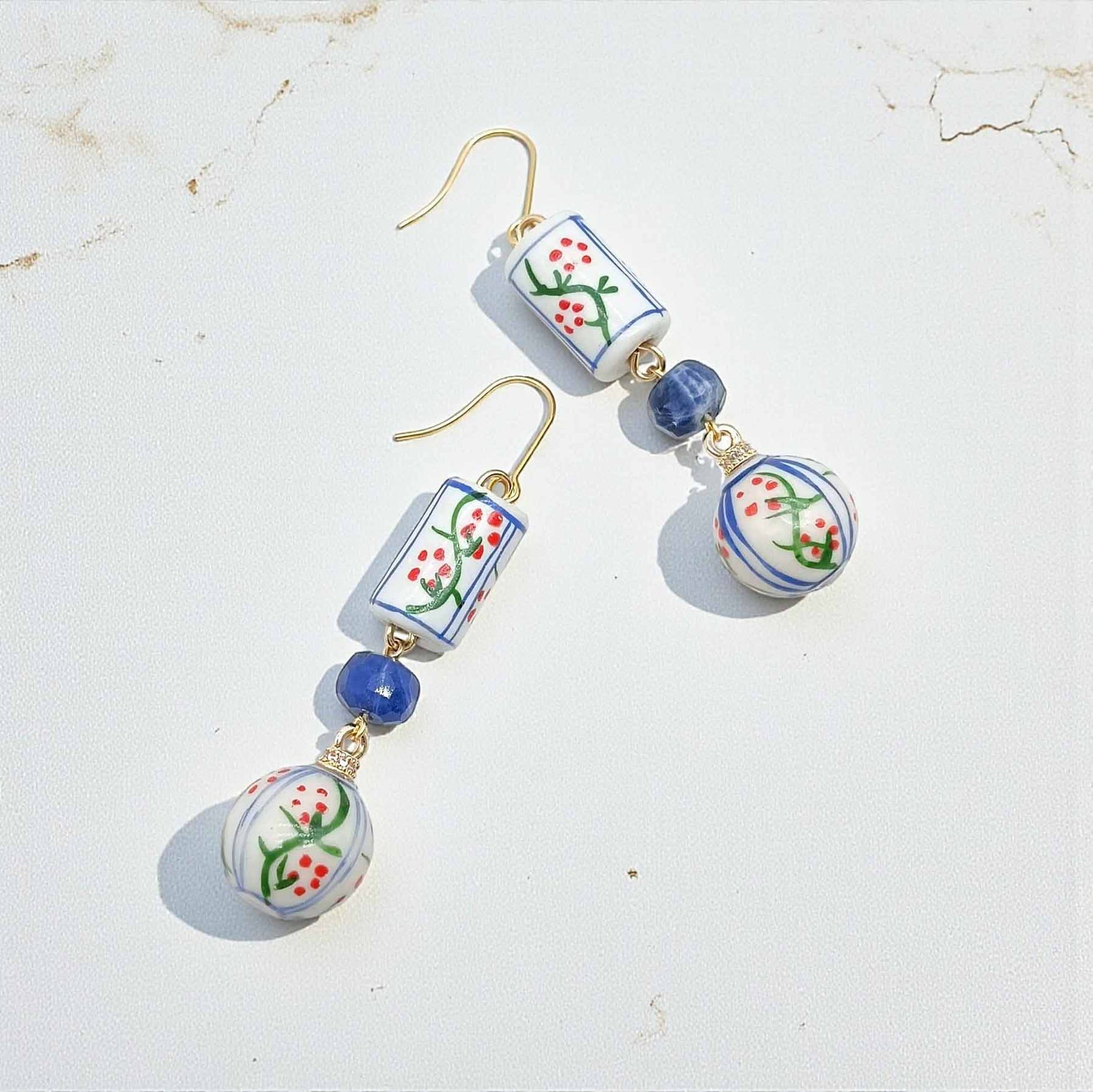 Pair of earrings with floral design beads on a light background