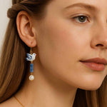 Close-up of a woman wearing an earring with a bird design.