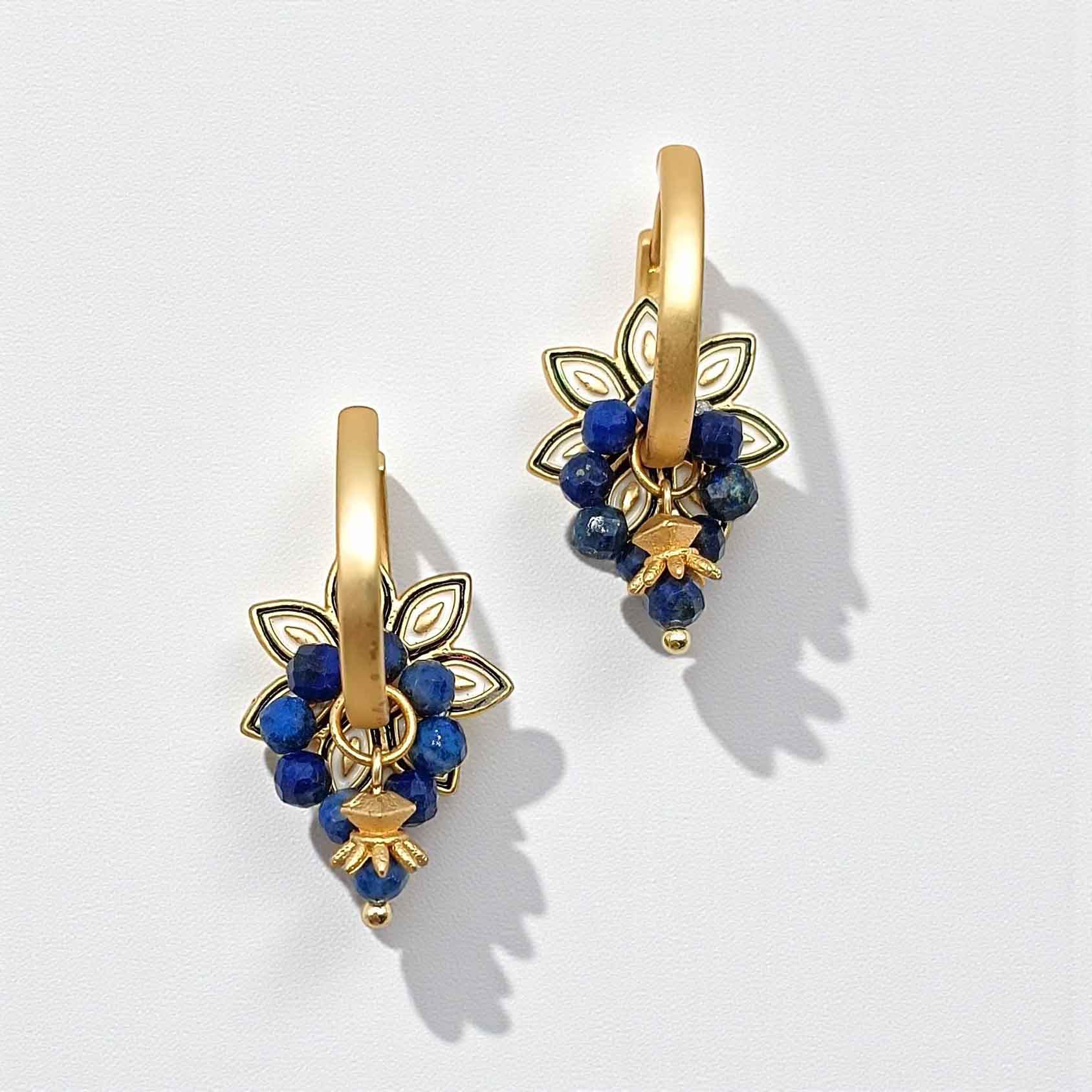 Gold and blue floral earrings on a white background