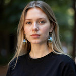 Woman wearing earrings with a blurred natural background