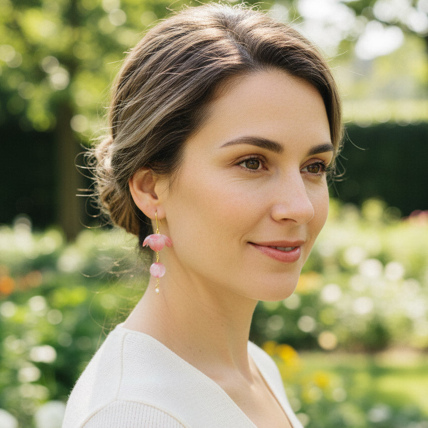 Model wearing green resin floral earring with gold hook in outdoor light.