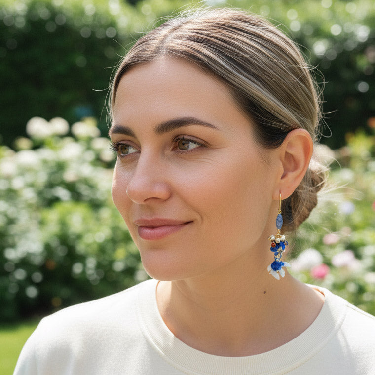 Model wearing hand-painted cloisonné koi fish earrings with gold hooks.
