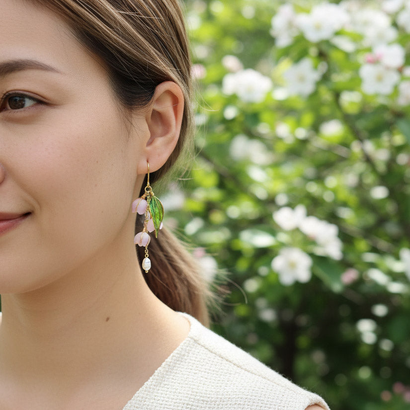 Woman wearing earrings with a blurred floral background