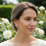 Model wearing pink lotus flower earrings with amazonite stones in garden.