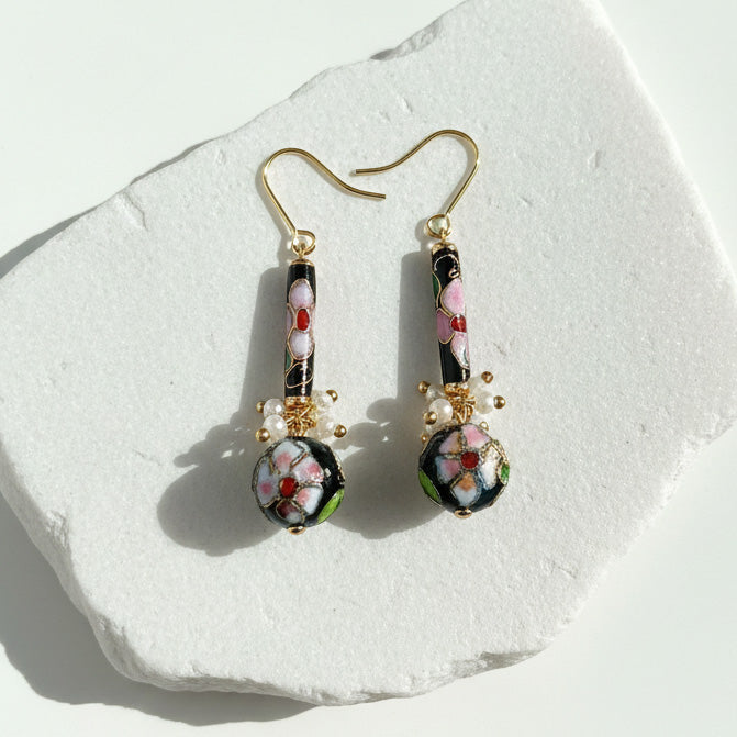 Vintage style cloisonné floral drop earrings on a white stone surface