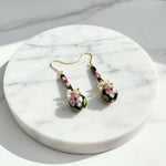 Cloisonné enamel bead earrings with freshwater pearl accents on a marble surface